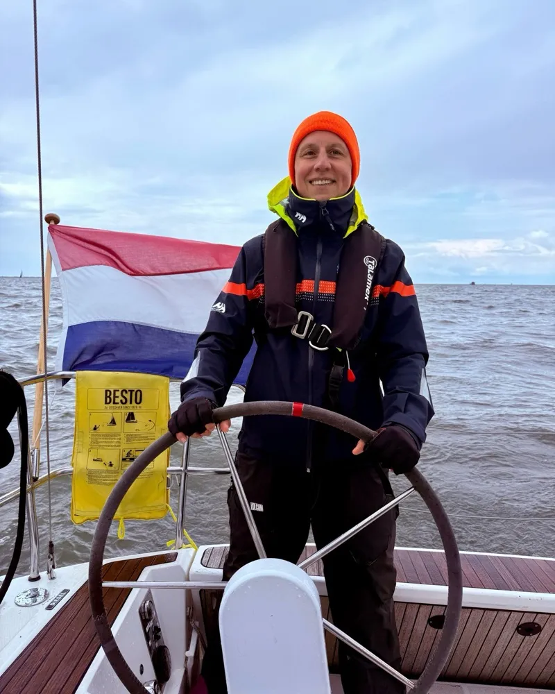 Alex at the helm of a sailing yacht